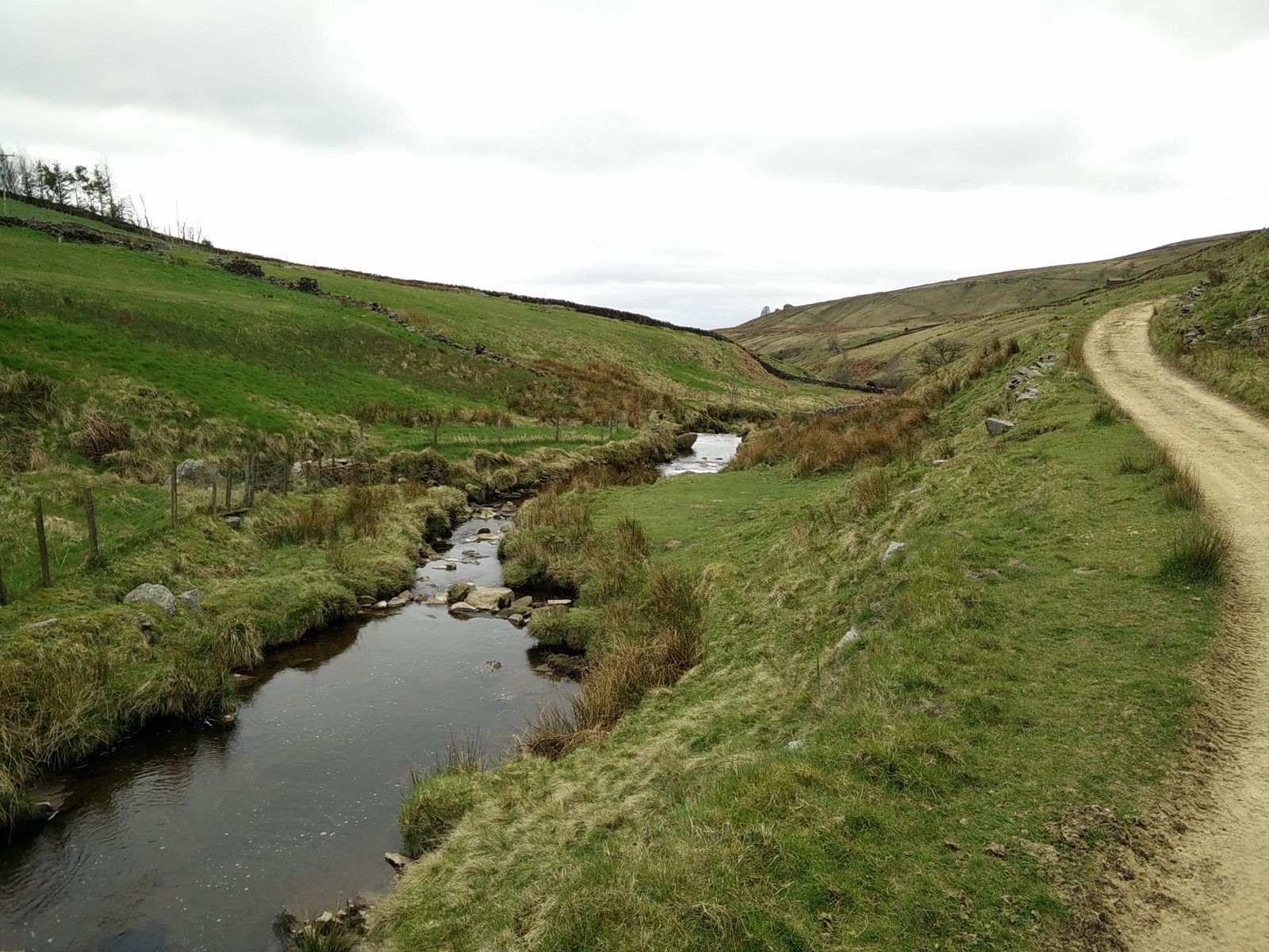 A small stream running through a green moorland valley in Calderdale, April 2017